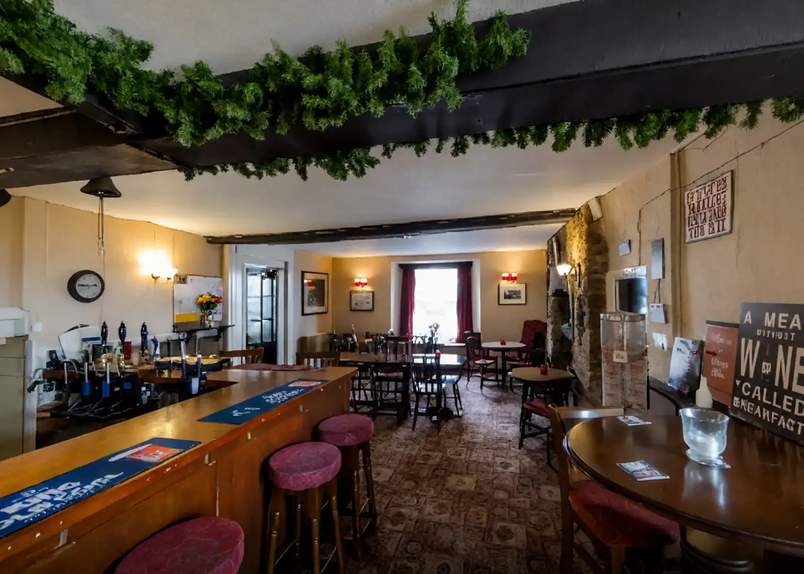 Tables and seating beside the bar under beamed ceilings
