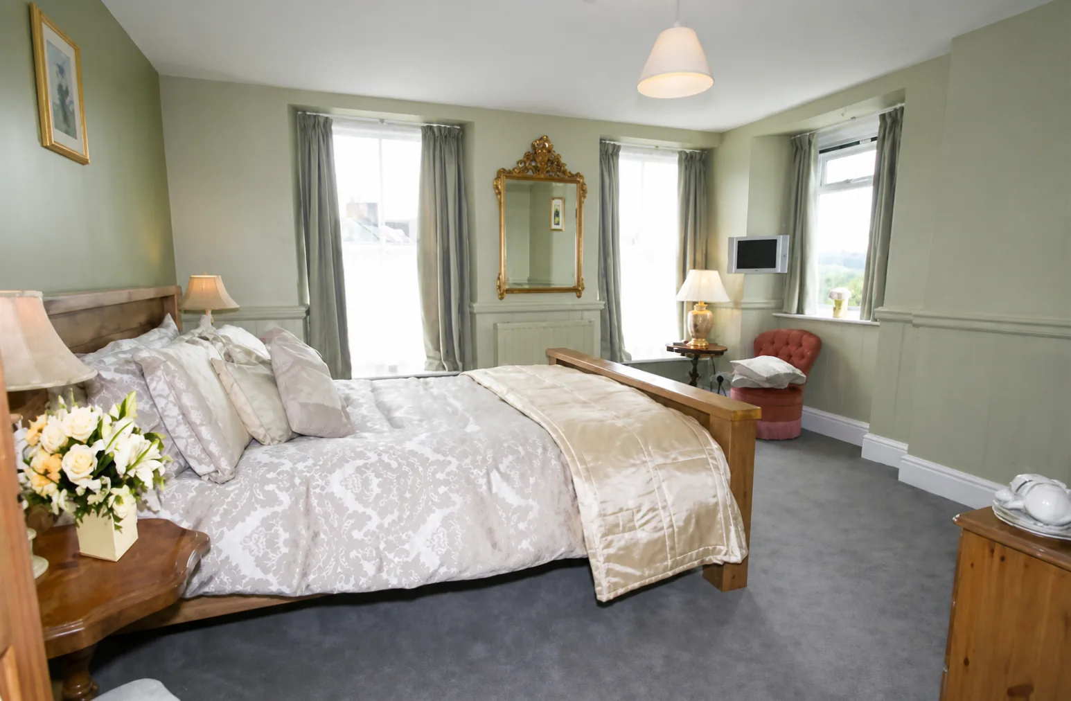 King room with wooden bed frame and sash windows